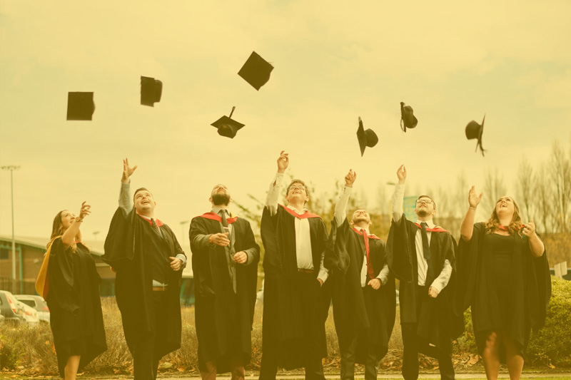 Students throwing graduation caps in the air